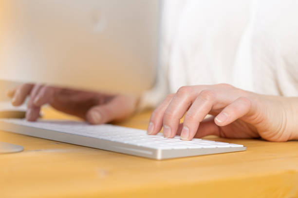 istock An image of a woman's hand is typing on a white keyboard on a wooden table. Selective focus 1317908692