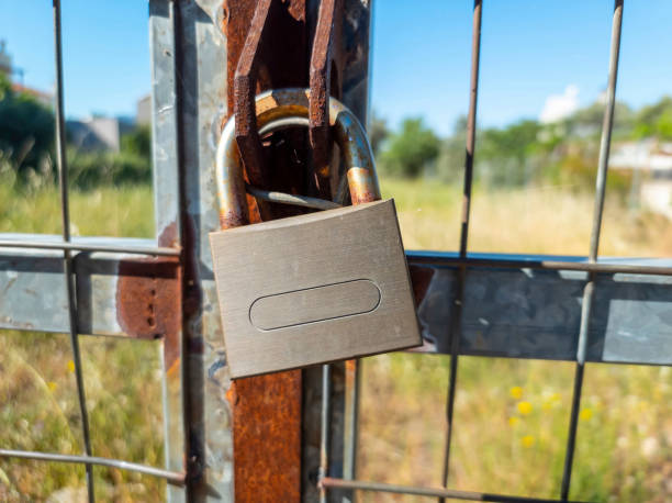 istock Rusty padlock locked on metal grid fence background. 1317910283