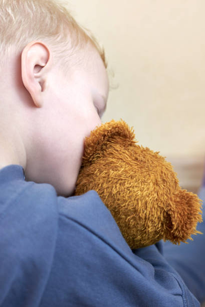 istock A three-year-old boy kisses his teddy bear, rear view. 1317911247