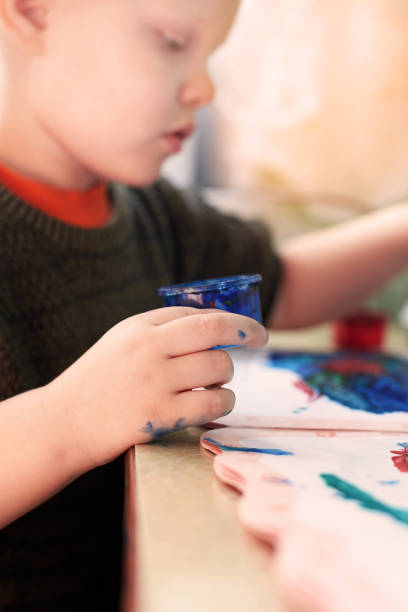 istock A three-year-old boy paints with gouache coloring. 1317911268