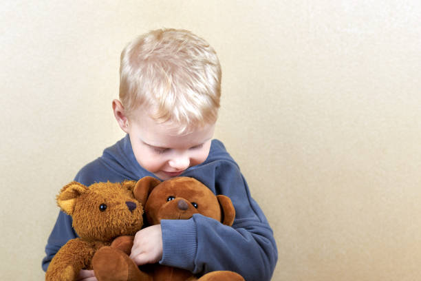 istock A three-year-old boy hugs two teddy bears. 1317911328