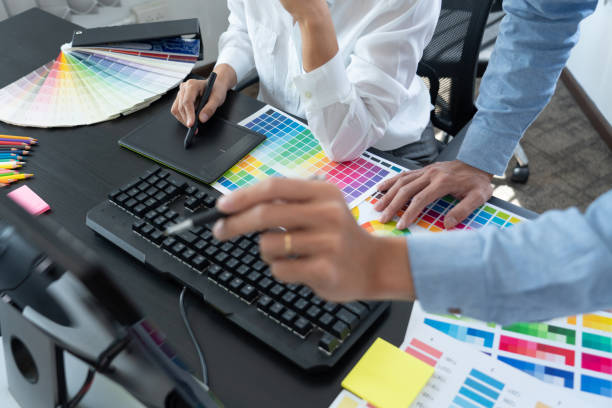 istock Graphic designer or creative working together coloring using graphics tablet and a stylus at desk with colleague 1317913263
