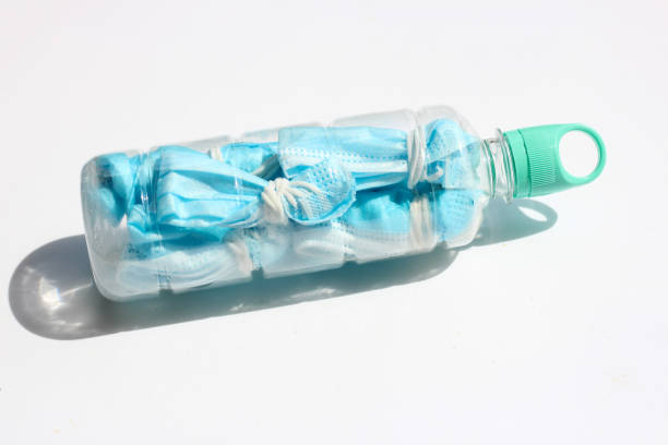 istock Prevent coronavirus, Used face masks in plastic bottle before littering 1317913768