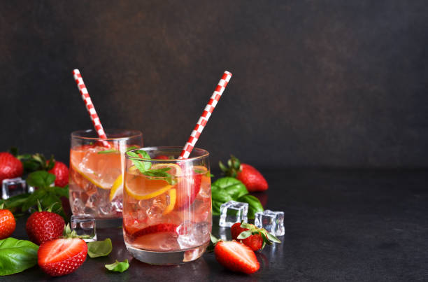 istock Summer drink. Cold lemonade with strawberries and basil on a concrete background. 1317915044