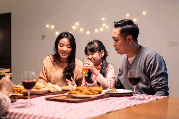 asiatische kleine mädchen genießen essen essen und verbringen zeit zusammen mit der familie in weihnachten und neujahr party. die kleine tochter fühlt sich glücklich, bei eltern und großeltern während des urlaubs zu bleiben. - 9 year old stock-fotos und bilder