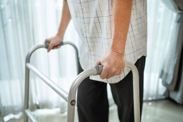 Close up hand of Asian Senior elderly disabled man patient walk slowly with walker at nursing home. Older handicapped male have weak leg use Zimmer frame to support. Medical therapy insurance concept. mano de cerca del paciente discapacitado mayor asiático camina lentamente con el caminante en el asilo de ancianos. los hombres discapacitados mayores tienen débil pierna utilizar marco zimmer para apoyar. concepto de seguro de terapia médica.