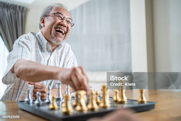 Portrait Of Asian Senior Elderly Male Spend Leisure Time Stay Home After Retirement Happy Smiling Old Man Enjoy Activity In House Play Chess Game With Friend Hospital Healthcare And Medical Concept Stock Photo - Download Image Now