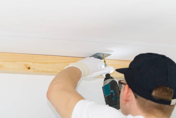 istock the master screws the metal corner to the concrete ceiling using a screwdriver, handyman 1317925248