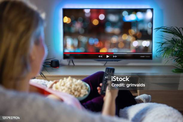 Woman Relaxing At Home In Evening And Watching Tv Stock Photo - Download Image Now - Television Set, Movie, Downloading