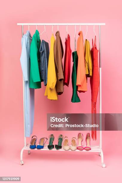 Vertical Shot Of Clothing Rail With Clothes Over Pink Background Stock Photo - Download Image Now