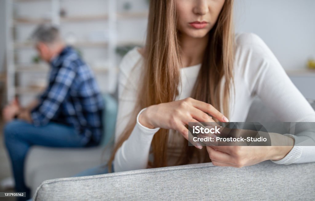 Cropped view of middle-aged woman taking off wedding ring, thinking about breakup with her husband at home, copy space Gray divorce concept. Cropped view of middle-aged woman taking off wedding ring, thinking about breakup with her husband at home, copy space. Mature couple getting late-in-life separation Divorce Stock Photo