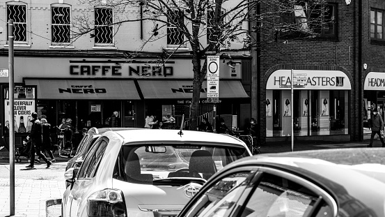Kingston Upon Thames London UK, May 04 2021, Black and White Image Row Of Cars Parked In Front Of A Cafe Nero Coffee Shop