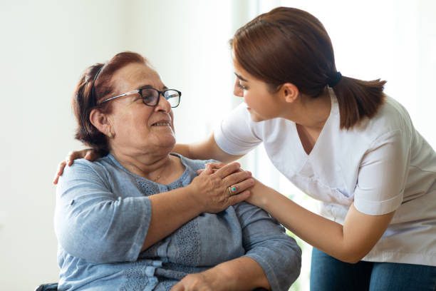 caring nurse talks with her elderly patient - social worker assistance home caregiver community outreach imagens e fotografias de stock