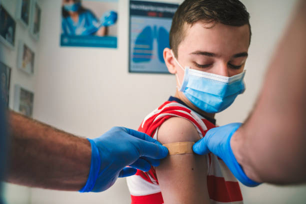 Patient Getting Vaccinated against COVID-19. Child, teenage boy vaccination. Coronavirus epidemic. Copy space. stock photo