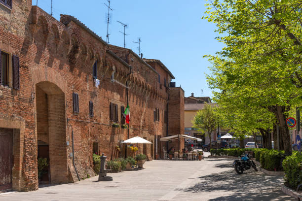 Buonconvento, one of the most beautiful villages of Italy. Buonconvento, Italy - April 22, 2018: Buonconvento, one of the most beautiful villages of Italy. Street in small historic medieval village in Tuscany with restaurant. ancient villages stock pictures, royalty-free photos & images