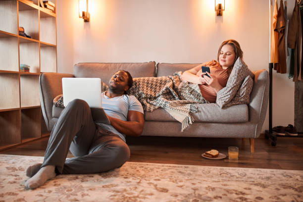 istock Romantic multiracial couple spending their weekend at home with the gadgets 1317944714