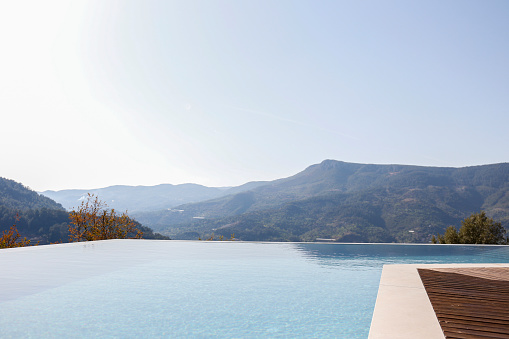 Infinity pool with panoramic mountain view. Close up, copy space for text, top view, background.