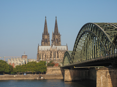 Koeln, Germany - Circa August 2019: Koelner Dom Sankt Petrus (meaning St Peter Cathedral) gothic church and Hohenzollernbruecke (meaning Hohenzollern Bridge) crossing the river Rhein