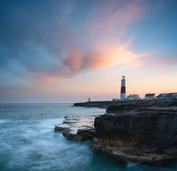 Evening descends upon Portland Bill Lighthouse on hate Dorset coast, UK. Composite image.