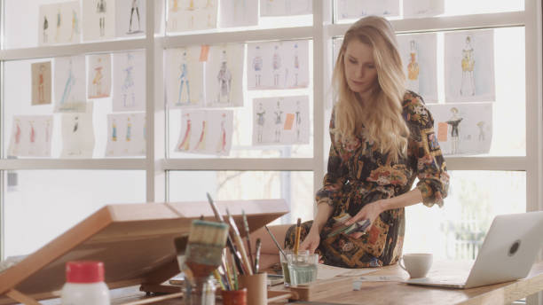 istock Female fashion designer at work. Sitting on desk. Creating new collection, picking projects 1317952881