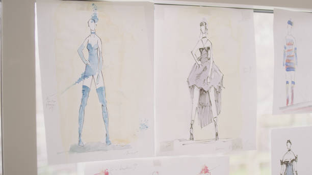 istock Female fashion designer at work. Creating new collection, picking projects hanging on a window 1317952912