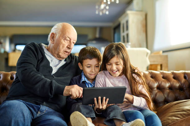 istock Grandfather using tablet PC with grandchildren 1317955458