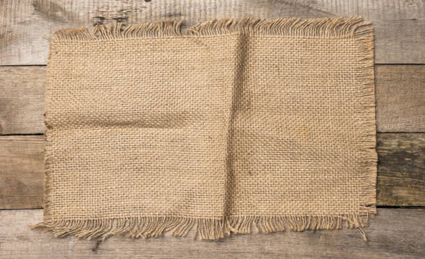 istock brown burlap fragment on gray wooden background, 1317955816