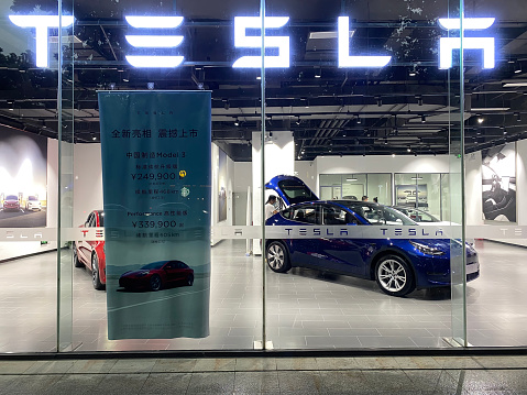 Wuhan.China-April 2021: front of Tesla store. customers inside Tesla retail shop selecting electric cars