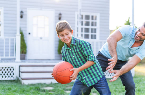 istock Father and son playing basketball in front of front yard 1317956149