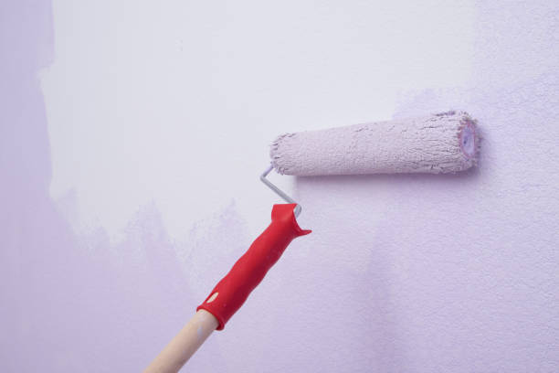 istock roller with handle, on the background of the wall, applying paint, close-up 1317956895