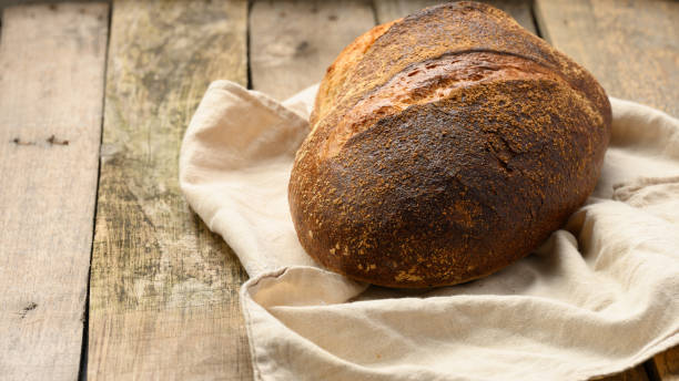 istock baked round bread made from white wheat board on wooden table 1317957053