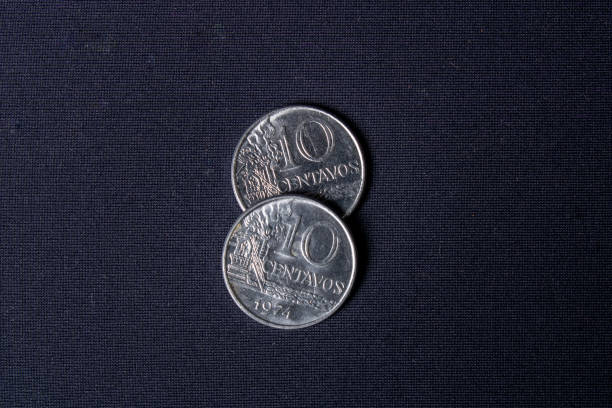 istock Two overlapping old ten-cent coins dated 1974 used in Brazil on a dark black background with light positioned from left to right. 1317957405