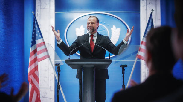 istock Charismatic Organization Representative Greeting Supporters at Conference in USA Government Building. Press Office Representative Delivering a Speech at a Summit. Minister Speaking to Congress. 1317961796