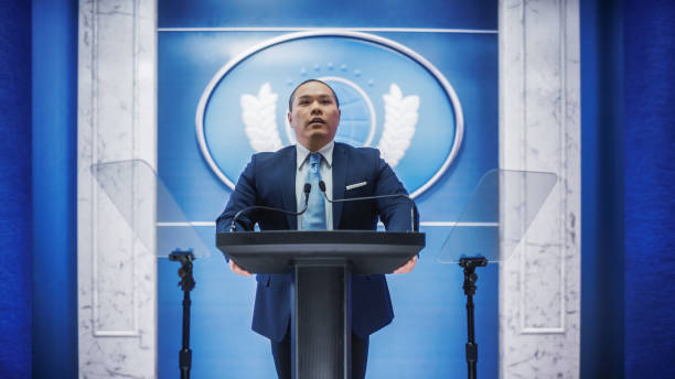istock Organization Chinese Representative Speaking at Press Conference in Government Building. Press Officer Delivering a Speech at Summit Meeting. Minister Speaking at Congress Hearing. 1317961808