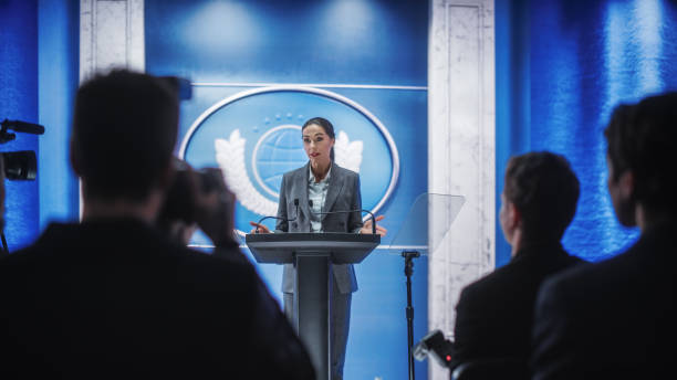 istock Organization Female Representative Speaking at a Press Conference in Government Building. Press Office Representative Delivering a Speech at a Summit. Minister Speaking to a Congress Hearing. 1317961813
