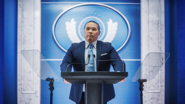 istock Organization Chinese Representative Speaking at Press Conference in Government Building. Press Officer Delivering a Speech at Summit Meeting. Minister Speaking at Congress Hearing. 1317961826