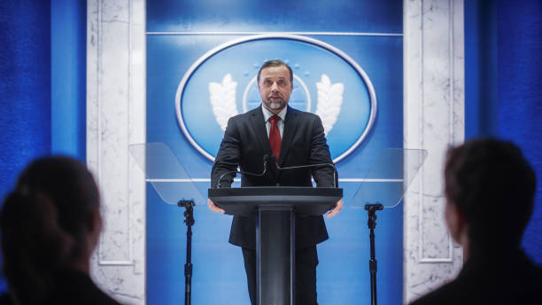 istock Charismatic Organization Representative Greeting Supporters at Conference in Government Building. Press Office Representative Delivering a Speech at a Summit. Minister Speaking to Congress. 1317961831