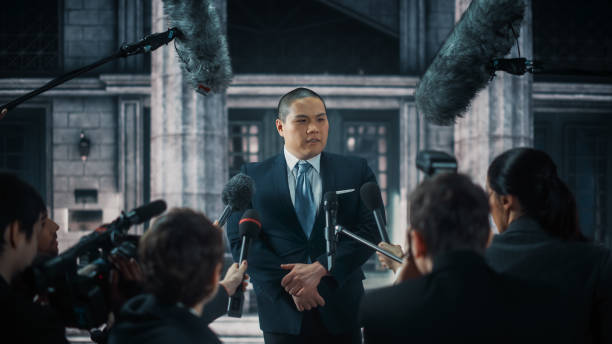 istock Organization Chinese Representative Answering Press Questions and Giving Interview Outside a Parliament, Court or Other Government Building. Press Officer or Businessman Crowded by Journalists. 1317961834