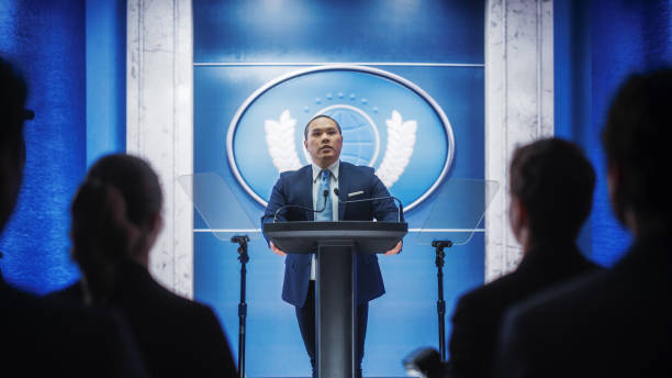 istock Organization Chinese Representative Speaking at Press Conference in Government Building. Press Officer Delivering a Speech at Summit Meeting. Minister Speaking at Congress Hearing. 1317961858