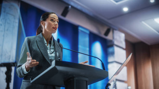 porträt der organisation weibliche vertreterin spricht bei der pressekonferenz im regierungsgebäude. vertreter des pressebüros bei einer rede auf dem gipfel. minister im gespräch mit der kongressanhörung. - pressekonferenz stock-fotos und bilder