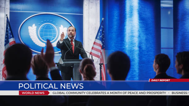 istock Inspiring Organization Representative Speaking at a Press Conference in Government Building. Press Officer Delivering a Speech at a Summit. Backdrop with American Flags. World Political News. 1317961886