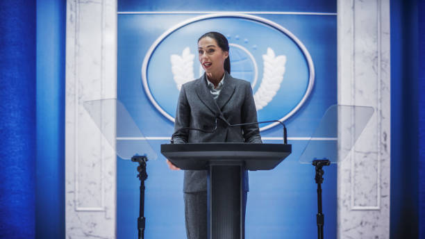 istock Organization Female Representative Speaking at a Press Conference in Government Building. Press Office Representative Delivering a Speech at a Summit. Minister Speaking to a Congress Hearing. 1317961905