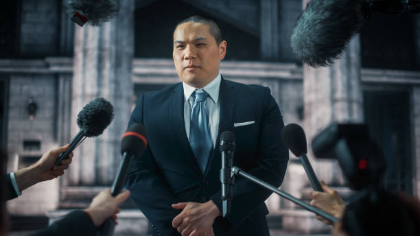 istock Organization Chinese Representative Answering Press Questions and Giving Interview Outside a Parliament, Court or Other Government Building. Press Officer or Businessman Crowded by Journalists. 1317961912