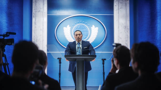 istock Organization Chinese Representative Speaking at Press Conference in Government Building. Press Officer Delivering a Speech at Summit Meeting. Minister Speaking at Congress Hearing. 1317961935