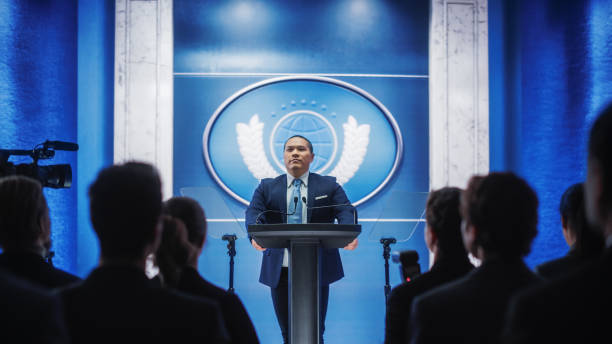 istock Organization Chinese Representative Speaking at Press Conference in Government Building. Press Officer Delivering a Speech at Summit Meeting. Minister Speaking at Congress Hearing. 1317961956