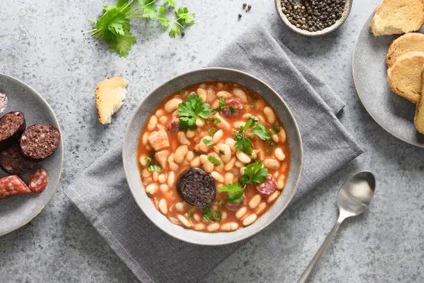 Photo of Spanish asturiana fabada on gray table. Top view.