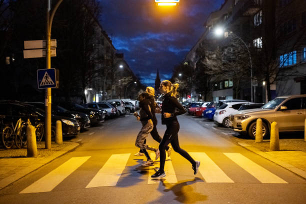 urban runners jogging together on city street at night - night running imagens e fotografias de stock