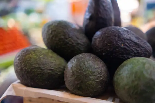 Photo of Pile of fresh avocados with blurry background