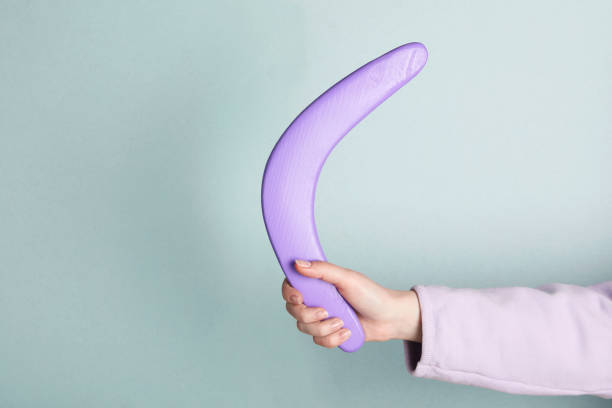 istock Woman holding boomerang on light grey background, closeup. Space for text 1317964377