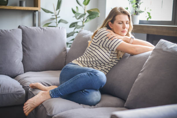 istock attractive middle aged woman sitting on the couch (negative emotions) 1317964461